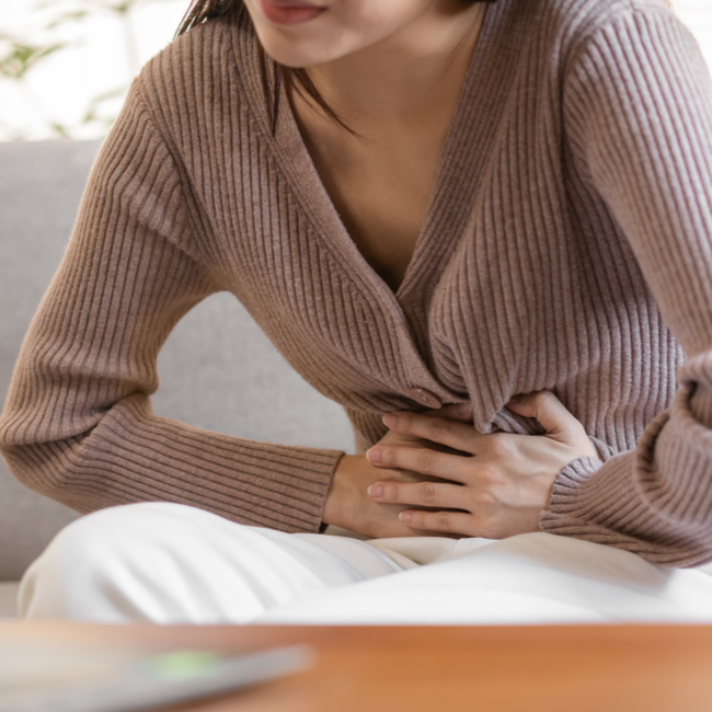 woman holding stomach with indigestion